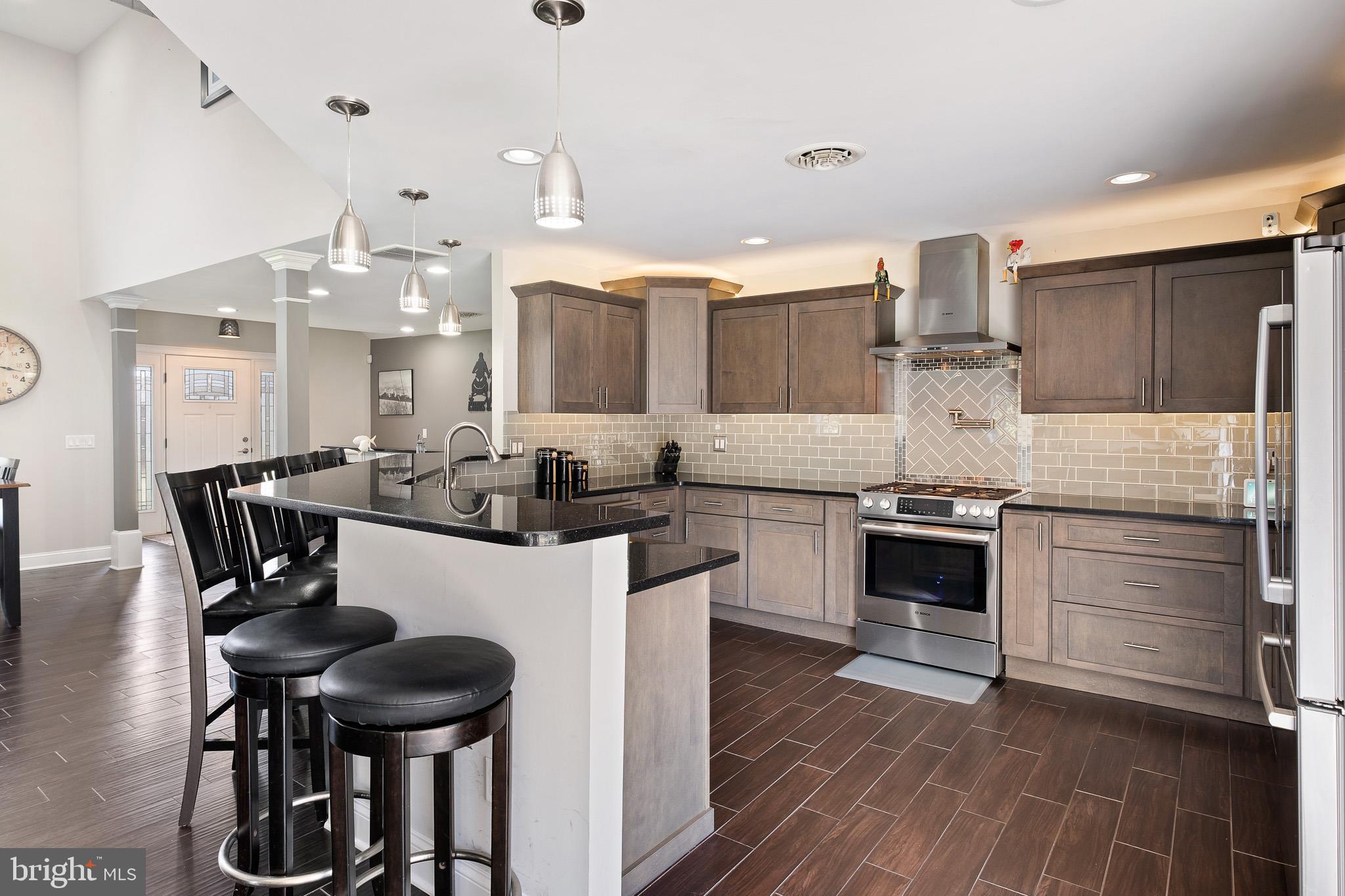 314 Concord Road Glen Mills, PA 19342 - Photo 20 of 42 a kitchen with stainless steel appliances a dining table chairs stove and cabinets