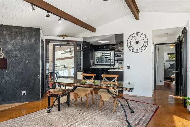 a living room with furniture a clock on wall and a window