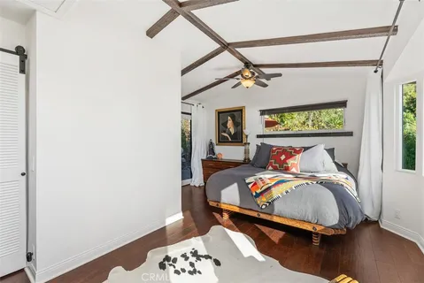 a bedroom with a bed and a dresser next to a window