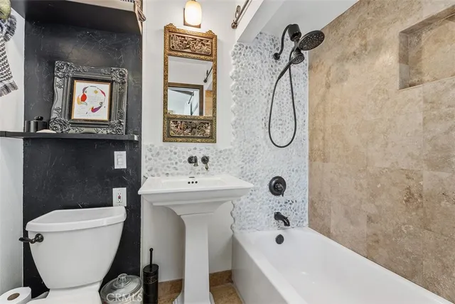 a bathroom with a toilet sink and mirror