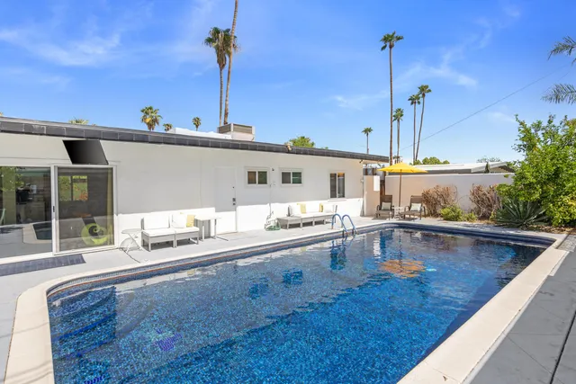 a living room with furniture a fireplace and a chandelier