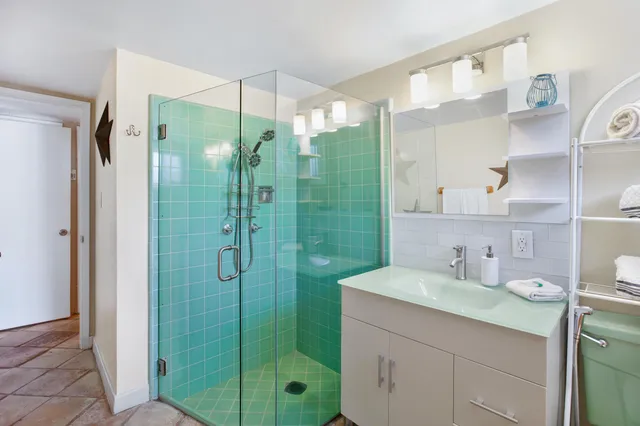 a bathroom with a shower sink and mirror
