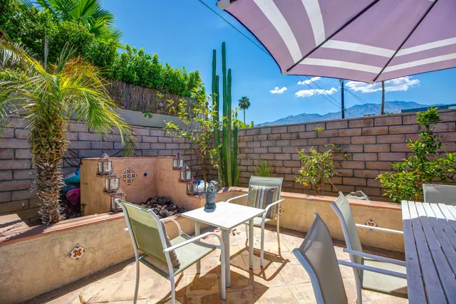 a view of a patio with table and chairs potted plants