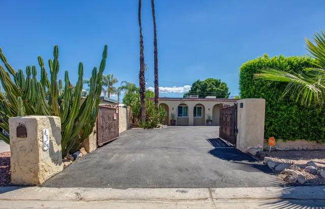 a view of a house with a yard and potted plants