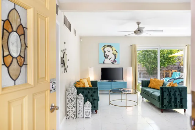 a kitchen with granite countertop a refrigerator a sink a counter and chairs