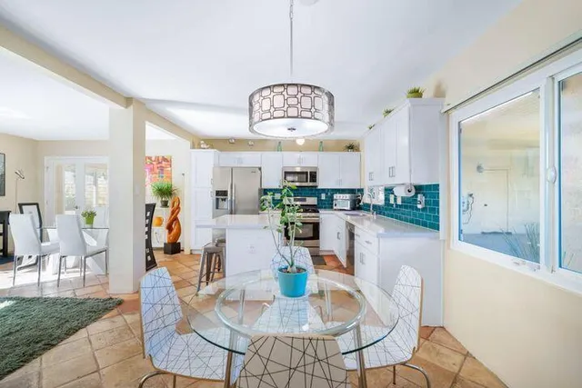 a view of a dining room with furniture a chandelier and wooden floor