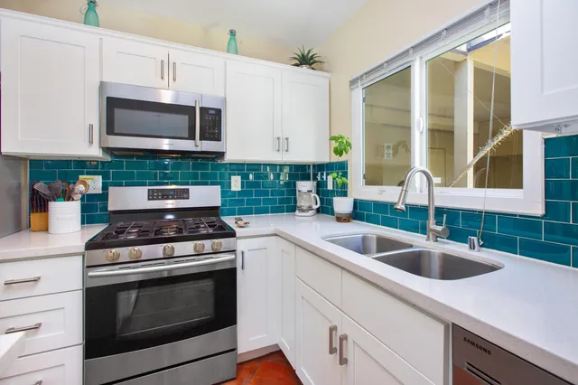 a kitchen with granite countertop a sink and a stove top oven