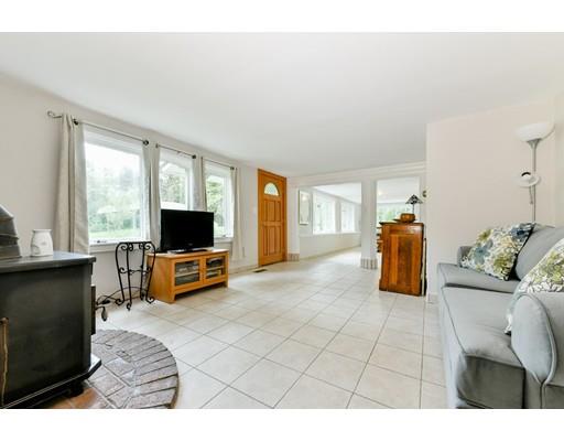 59 Indian Lane Canton, MA 02021 - Photo 2 of 25 a living room with furniture a flat screen tv and a large window