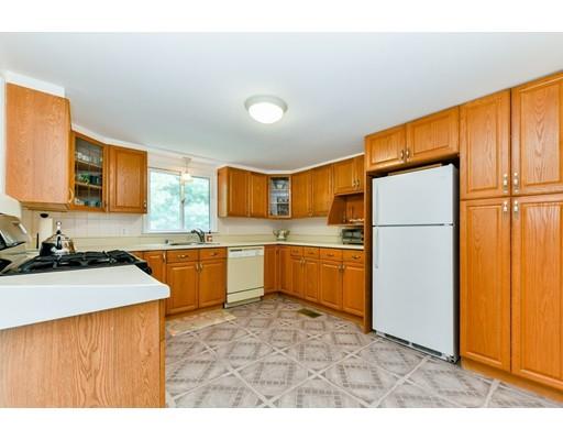 59 Indian Lane Canton, MA 02021 - Photo 4 of 25 a kitchen with stainless steel appliances granite countertop a refrigerator a sink dishwasher a stove with wooden cabinets