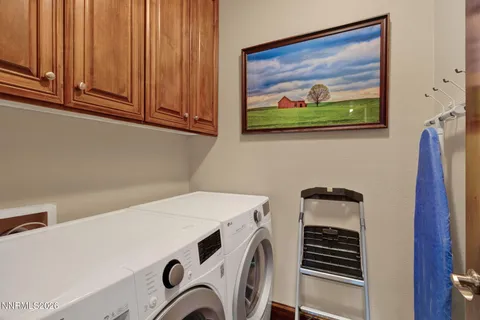 a utility room with dryer washer and a view of living room