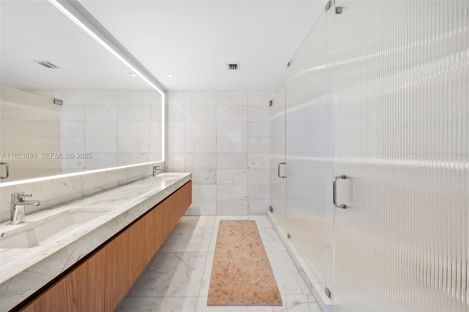 500 Alton Road, Unit 3604 Miami Beach, FL 33139 - Photo 16 of 45 a bathroom with a double vanity sink and mirror with shower