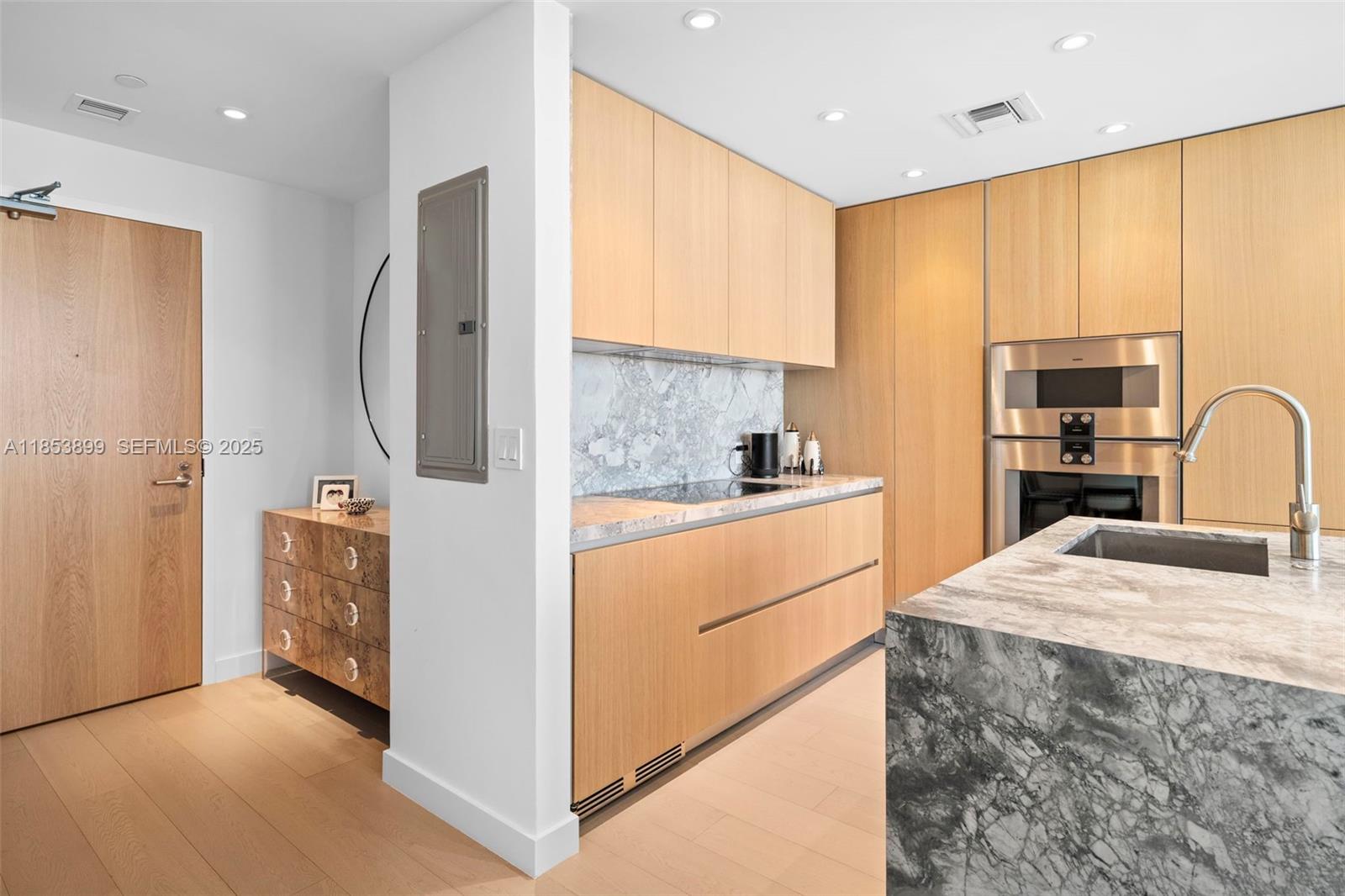 500 Alton Road, Unit 3604 Miami Beach, FL 33139 - Photo 5 of 45 a kitchen with stainless steel appliances granite countertop a refrigerator a stove and a sink with wooden floor