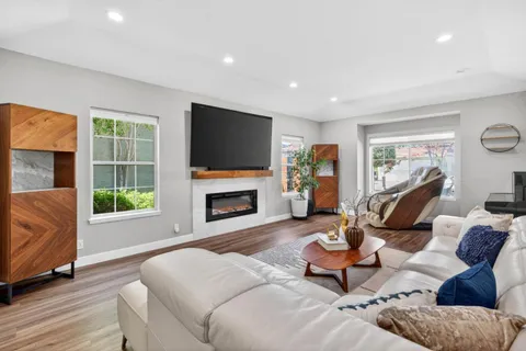 a living room with furniture a flat screen tv and a fireplace
