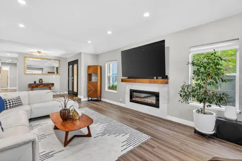 a living room with furniture a fireplace and a flat screen tv