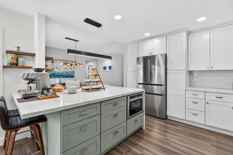 a kitchen with stainless steel appliances sink stove refrigerator and cabinets
