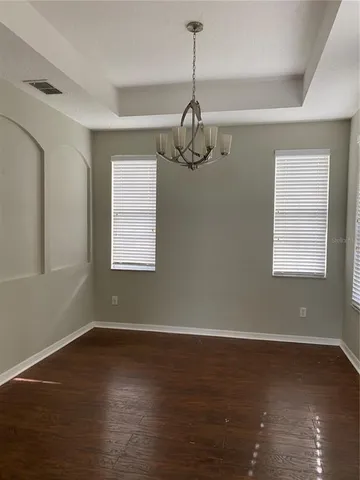 a view of a room with wooden floor air conditioner and windows