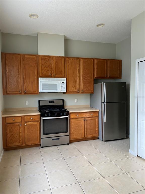 13638 Ancilla Boulevard Windermere, FL 34786 - Photo 7 of 16 a kitchen with stainless steel appliances granite countertop a stove a refrigerator and a sink