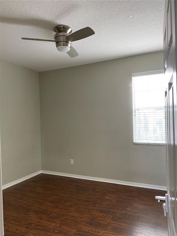 13638 Ancilla Boulevard Windermere, FL 34786 - Photo 8 of 16 an empty room with wooden floor fan and windows