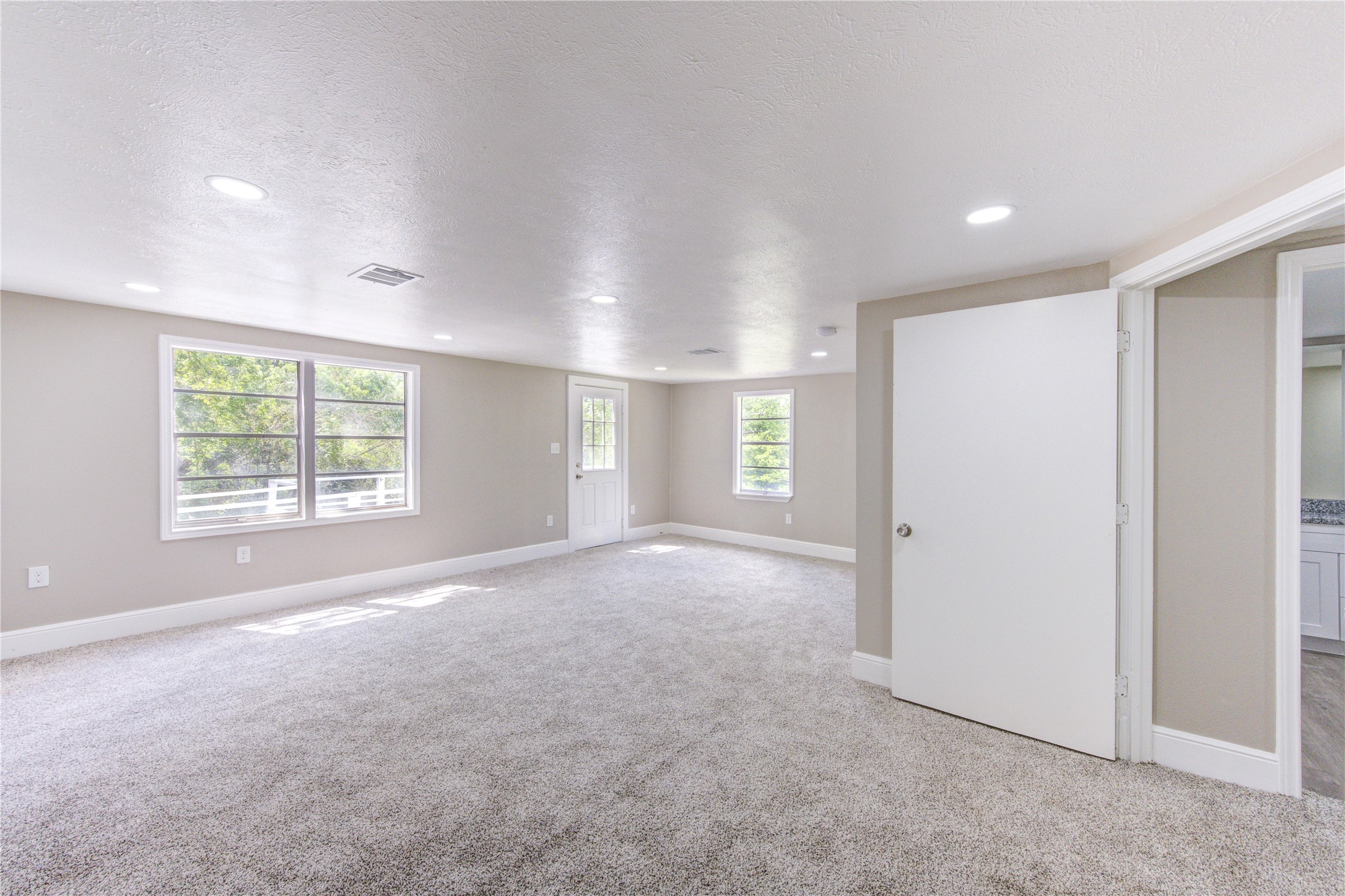 15170 McRae Lake Conroe, TX 77303 - Photo 19 of 25 a view of a big room with windows and chandelier fan