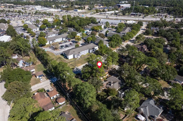 an aerial view of residential houses with outdoor space and trees