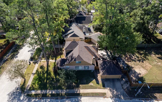 an aerial view of a house with a yard and large trees