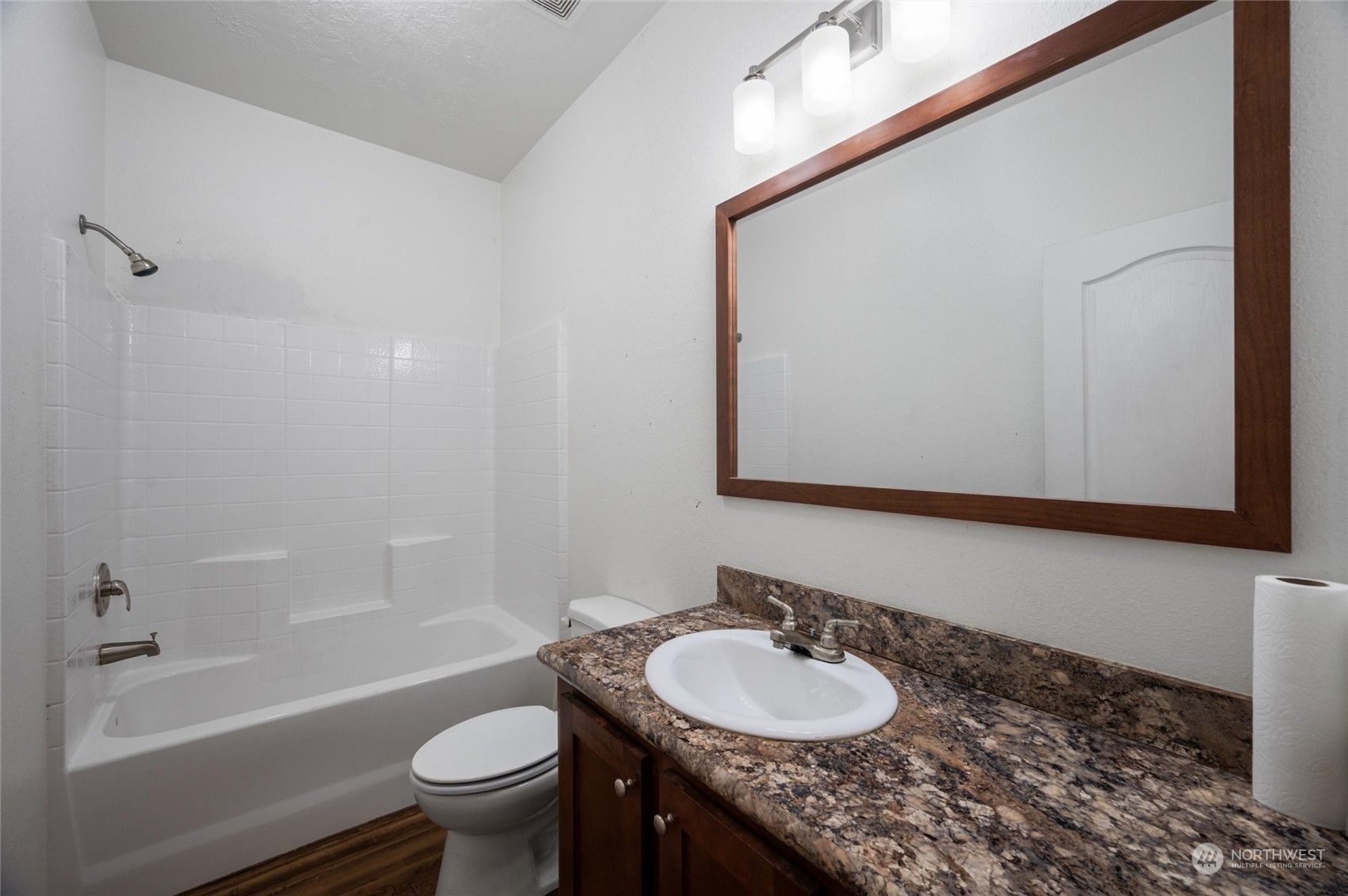 700 North Reed Street, Unit 21 Sedro-Woolley, WA 98284 - Photo 22 of 28 a bathroom with a granite countertop sink toilet a large mirror a bathtub and shower
