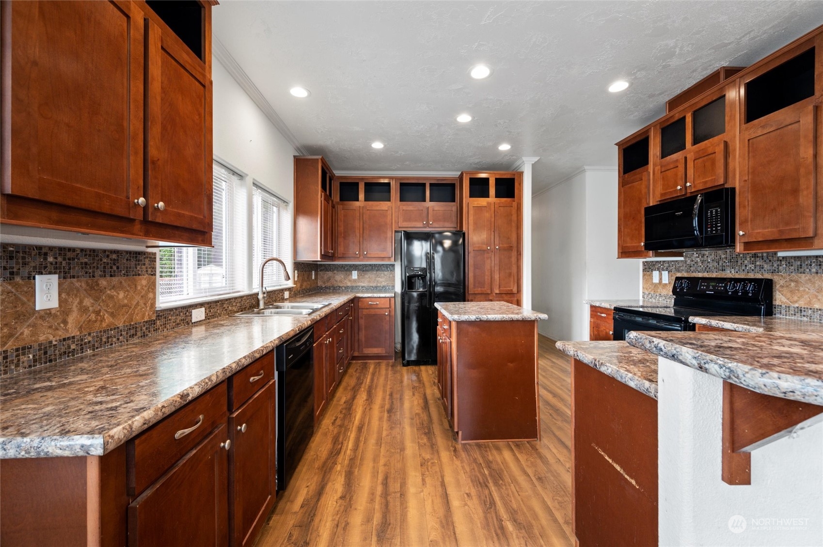 700 North Reed Street, Unit 21 Sedro-Woolley, WA 98284 - Photo 9 of 28 a large kitchen with stainless steel appliances granite countertop a large stove top oven a sink dishwasher and microwave oven with large wooden cabinets