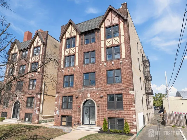 a front view of a residential apartment building with a yard