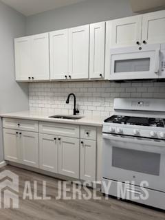 118 West 2nd Avenue, Unit 4 Roselle, NJ 07203 - Photo 4 of 12 a kitchen with white cabinets and appliances