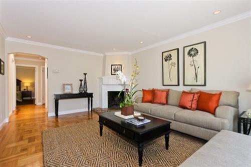 This gracious livingroom features warm parquet floors, wood-burning fireplace and crown moldings.