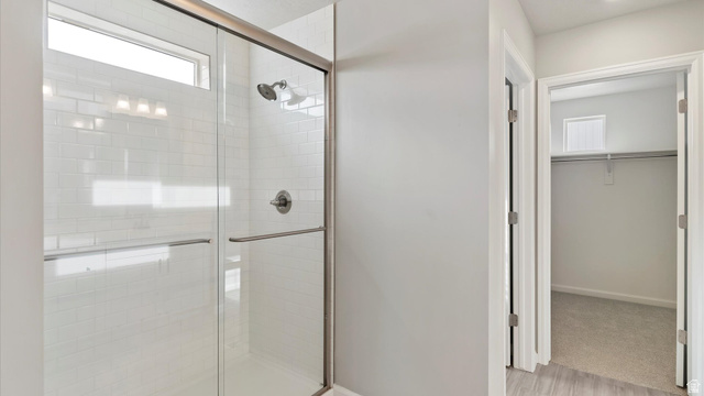 82 Provo River Road, Unit 251 Saratoga Springs, UT 84045 - Photo 22 of 32 Spacious walk-in shower featuring subway tile surround, clear glass enclosure, and brushed nickel fixtures