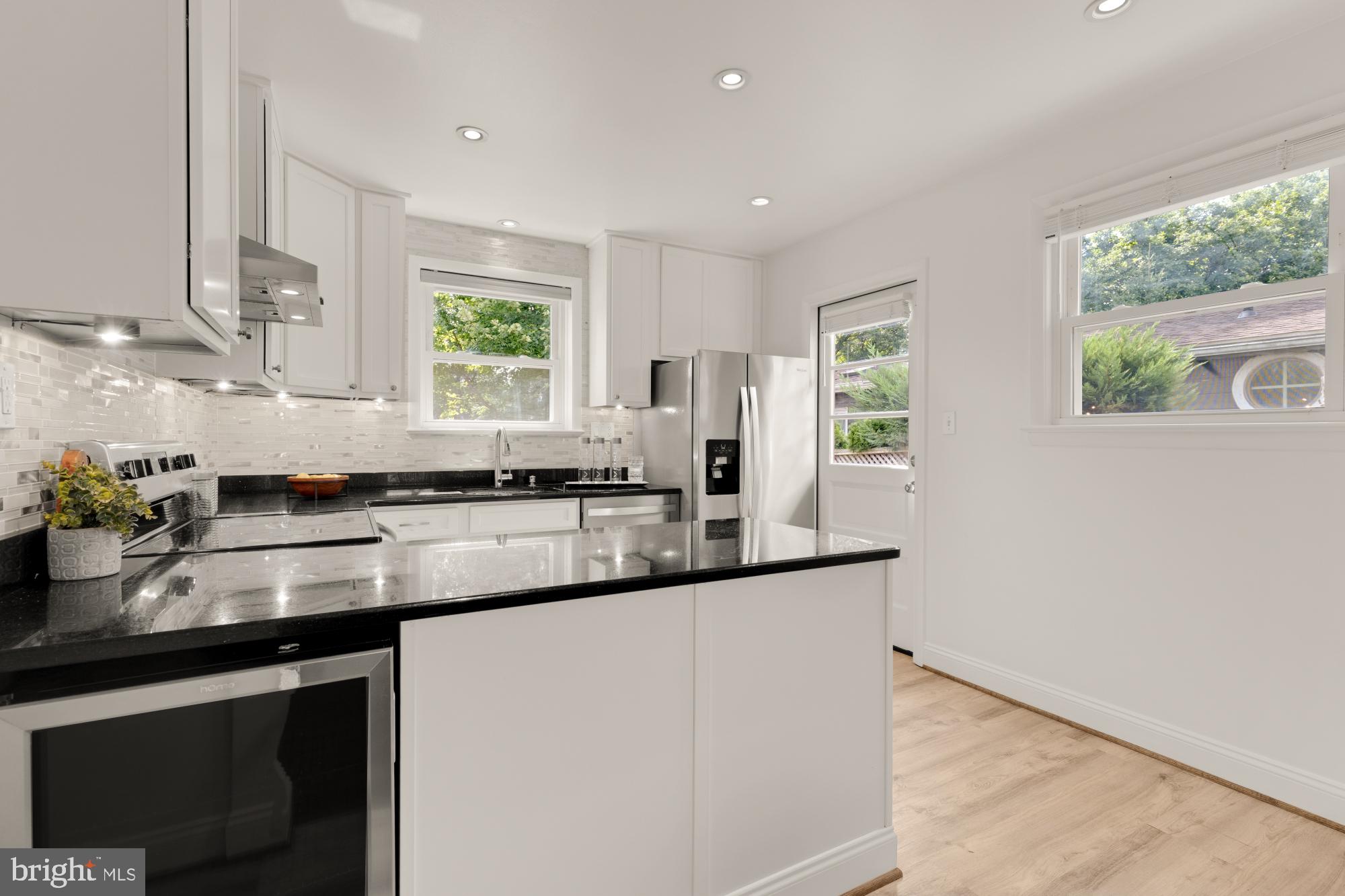 9811 Dallas Avenue Silver Spring, MD 20901 - Photo 16 of 45 a kitchen with stainless steel appliances granite countertop a sink a stove a counter space and a window