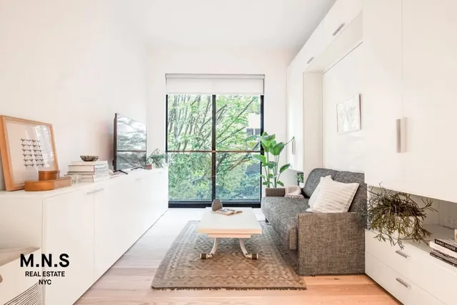 a living room with furniture a flat screen tv and a window