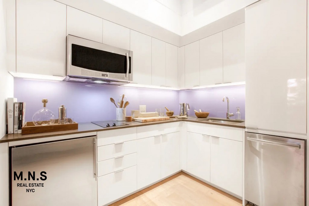 335 East 27th Street, Unit 9A Manhattan, NY 10016 - Photo 5 of 11 a kitchen with stainless steel appliances a sink and a microwave