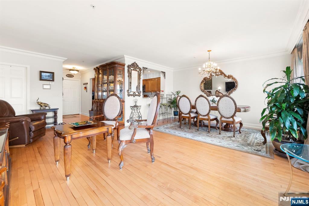 108 The Promenade, Unit 108 Edgewater, NJ 07020 - Photo 16 of 49 a living room with furniture a clock and wooden floor
