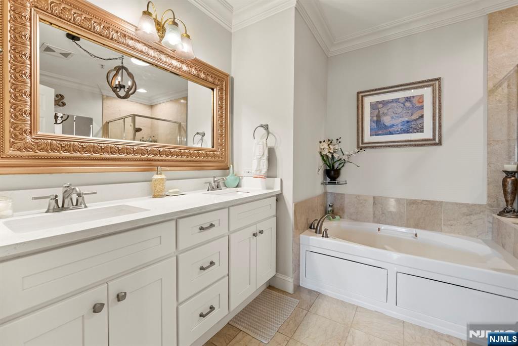 108 The Promenade, Unit 108 Edgewater, NJ 07020 - Photo 32 of 49 a bathroom with a tub sink and mirror