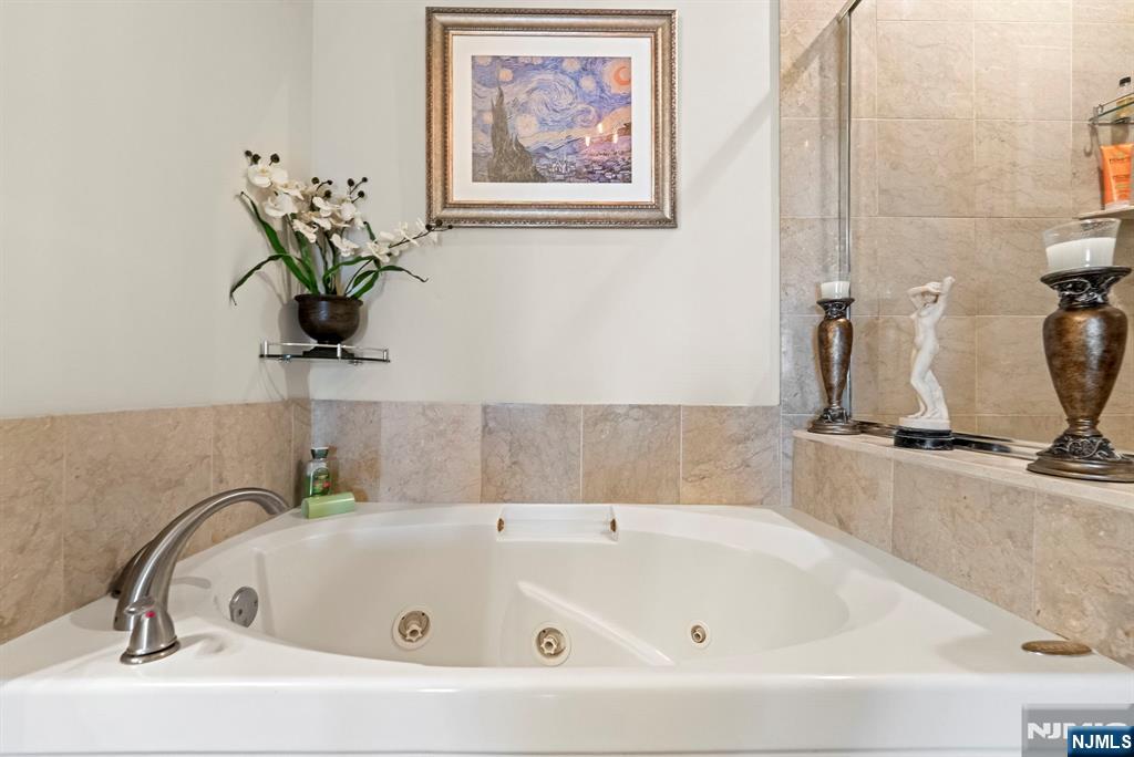 108 The Promenade, Unit 108 Edgewater, NJ 07020 - Photo 34 of 49 a bathroom with a tub