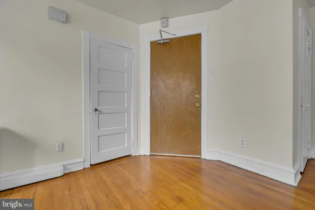 an empty room with wooden floor and closet