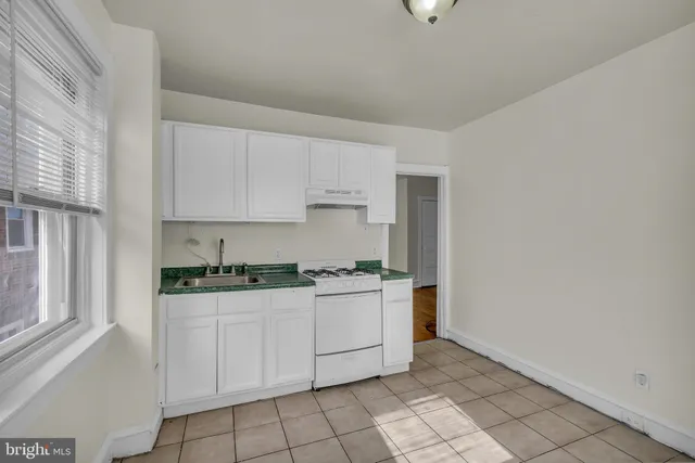a kitchen with granite countertop white cabinets and white appliances