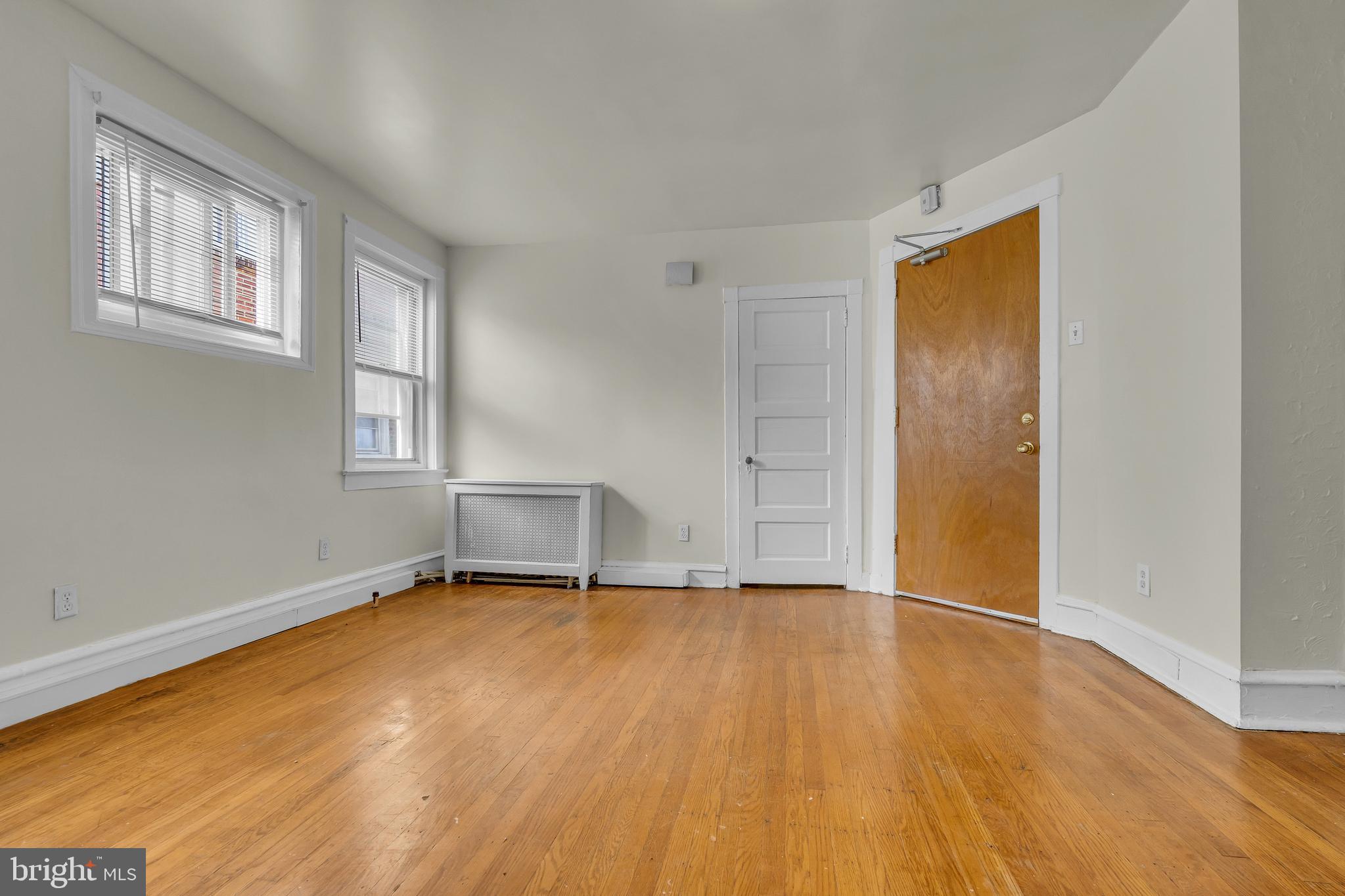 5121 East Roosevelt Boulevard, Unit 2 Philadelphia, PA 19124 - Photo 3 of 23 an empty room with wooden floor and windows