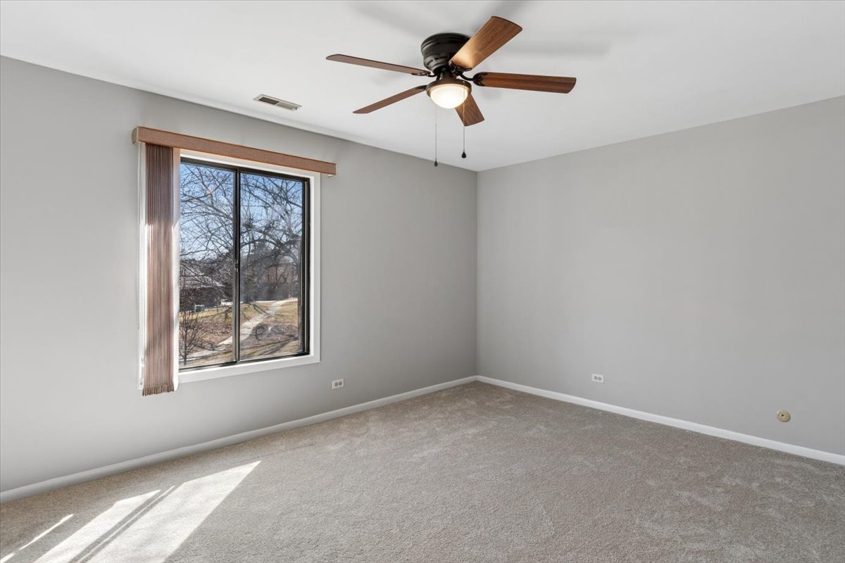 1733 Harrow Court, Unit B Wheaton, IL 60189 - Photo 15 of 23 an empty room with a window and a fan