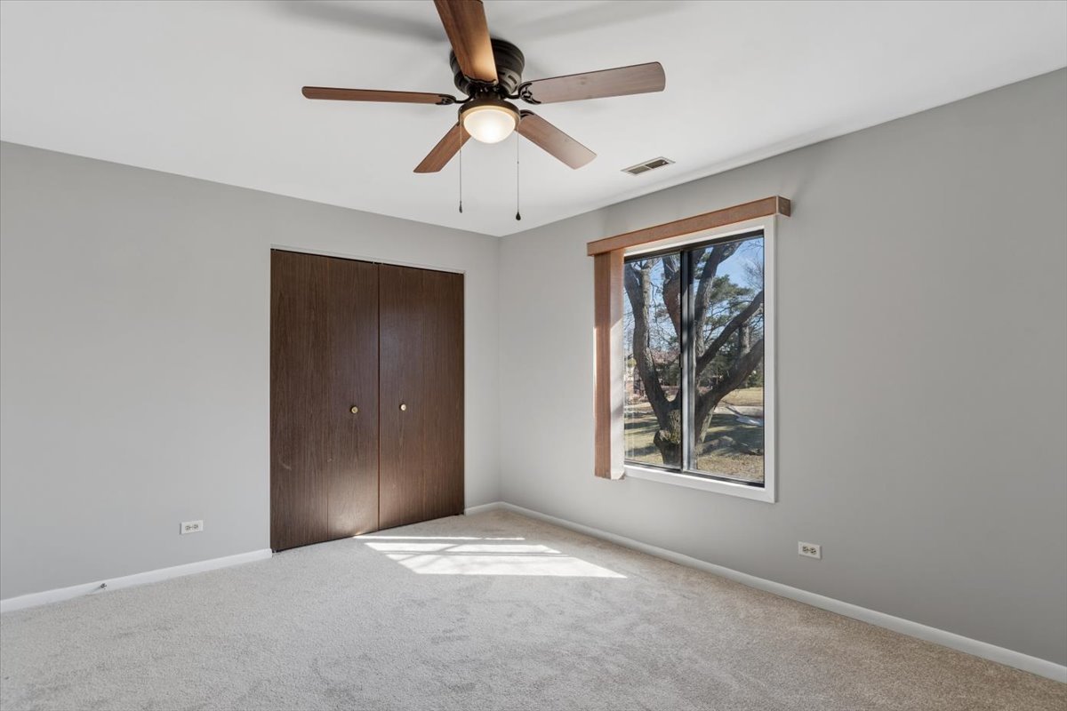 1733 Harrow Court, Unit B Wheaton, IL 60189 - Photo 17 of 23 an empty room with windows and fan