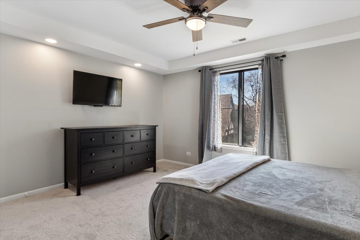 1733 Harrow Court, Unit B Wheaton, IL 60189 - Photo 20 of 23 a bedroom with a bed and a flat screen tv