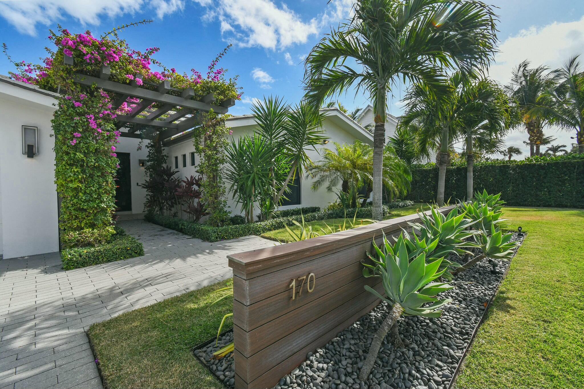 170 Beacon Lane Jupiter Inlet Colony, FL 33469 - Photo 2 of 46 a garden with flowers in front of it