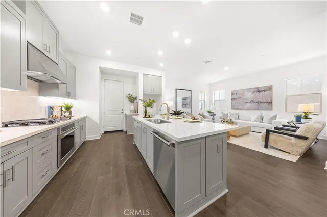 a kitchen with stainless steel appliances a sink stove and cabinets