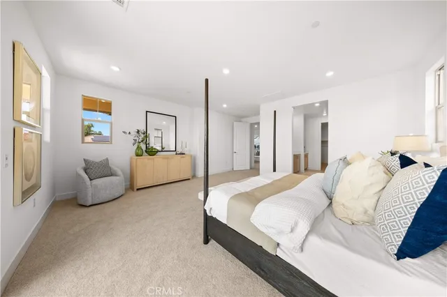 a spacious en suite bathroom with a granite countertop double vanity and a mirror