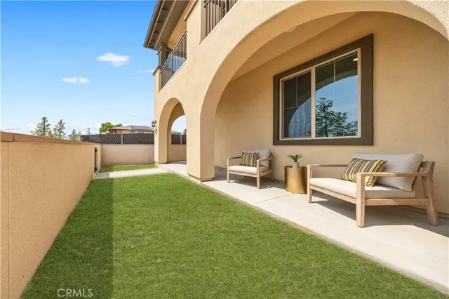 a view of a two chairs in the patio next to a yard