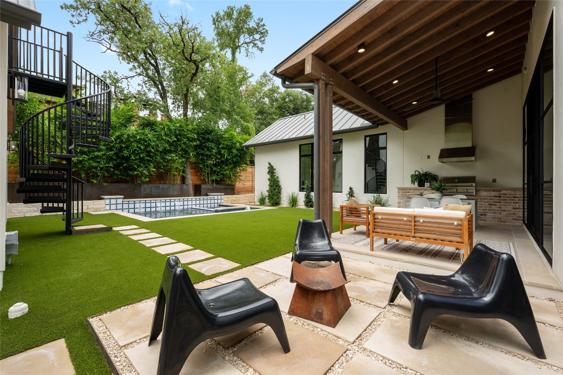 a view of a backyard with swimming pool and sitting area