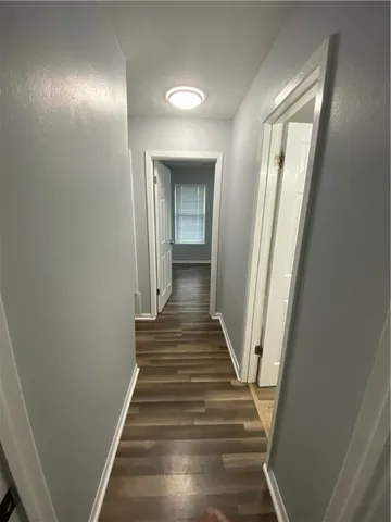 a view of a hallway with wooden floor and staircase