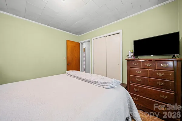 a bedroom with a bed and a flat screen tv